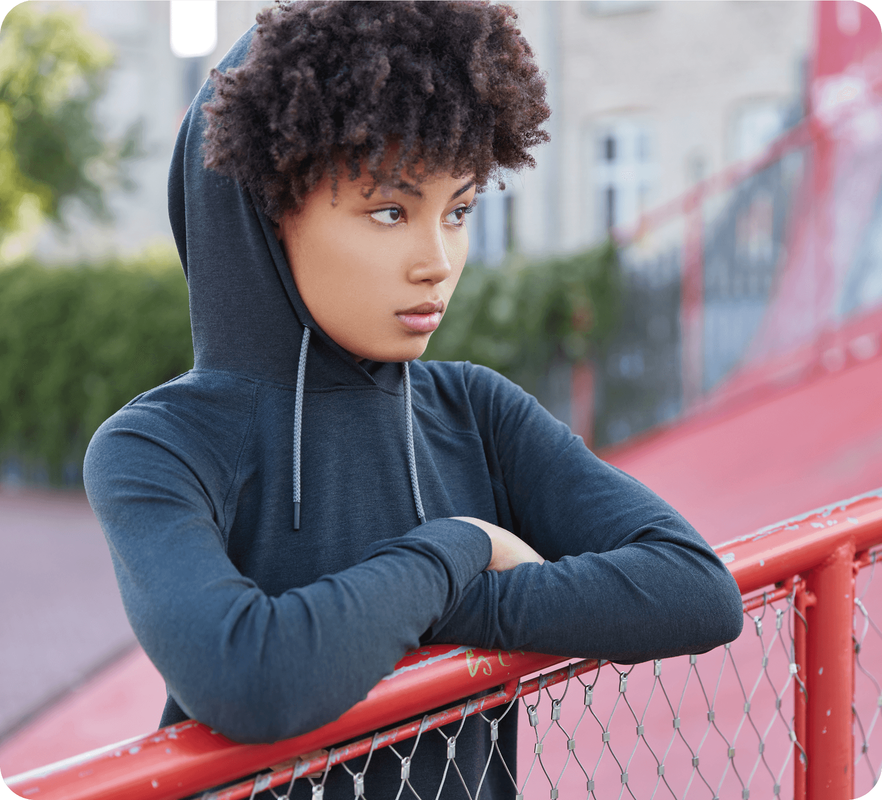 A teenager leaning on a railing, looking away with a withdrawn expression